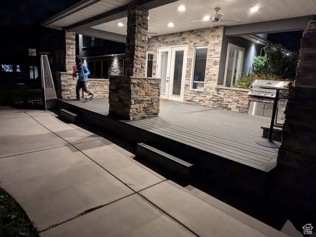 Patio at twilight featuring a wooden deck, area for grilling, and french doors