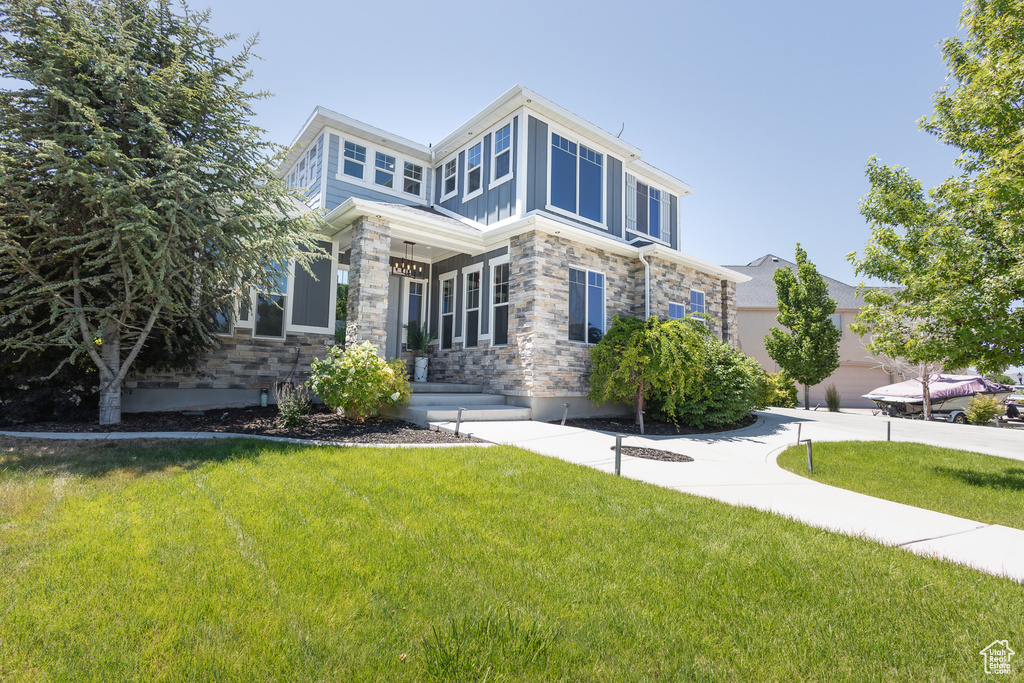 View of front of home with a garage and a front lawn