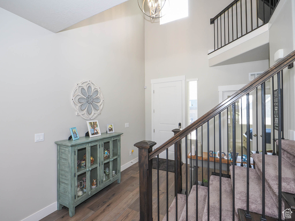 Interior space featuring a chandelier, a high ceiling, and dark hardwood / wood-style flooring