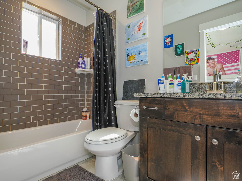 Full bathroom featuring vanity, toilet, and shower / tub combo with curtain