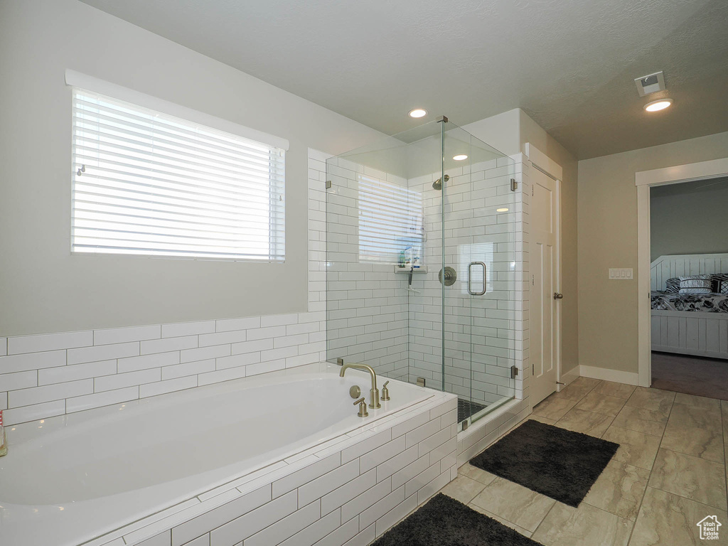 Bathroom featuring tile flooring and separate shower and tub