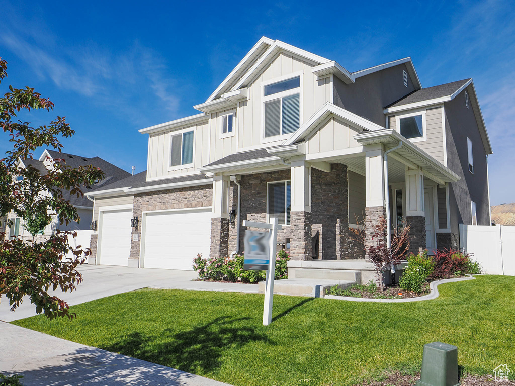 Craftsman-style house featuring a garage and a front yard