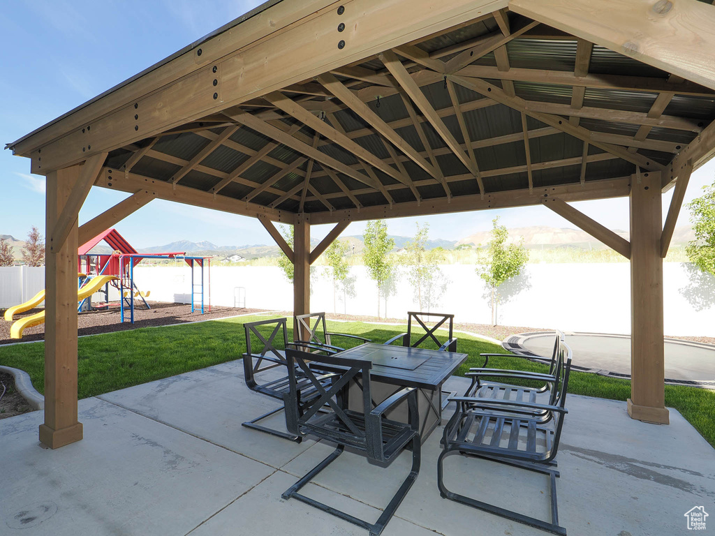 View of patio / terrace featuring a playground, a gazebo, and a water view