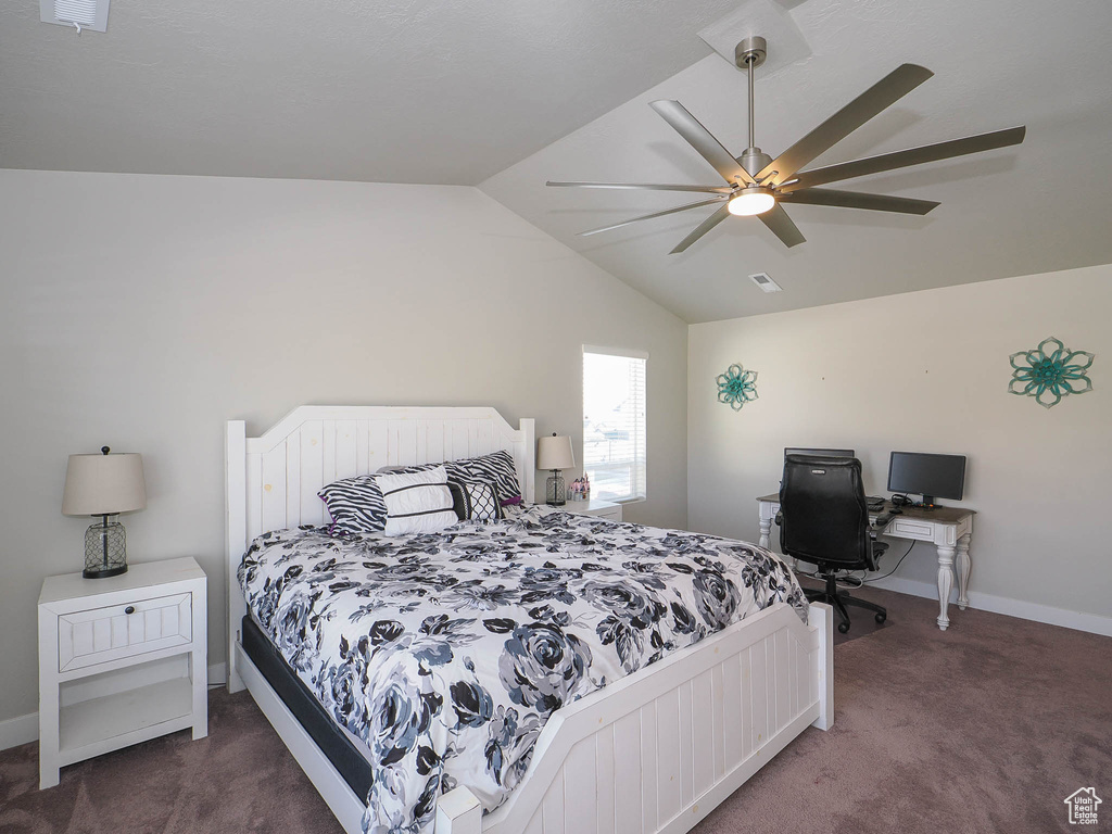 Carpeted bedroom with vaulted ceiling and ceiling fan