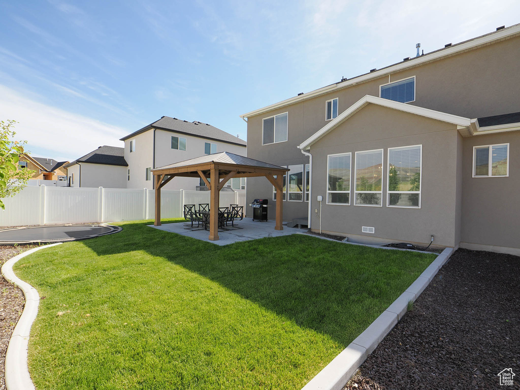 Back of house featuring a patio area, a lawn, and a gazebo