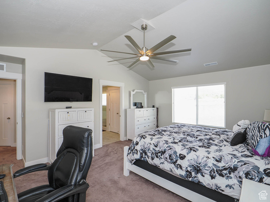 Carpeted bedroom featuring vaulted ceiling and ceiling fan