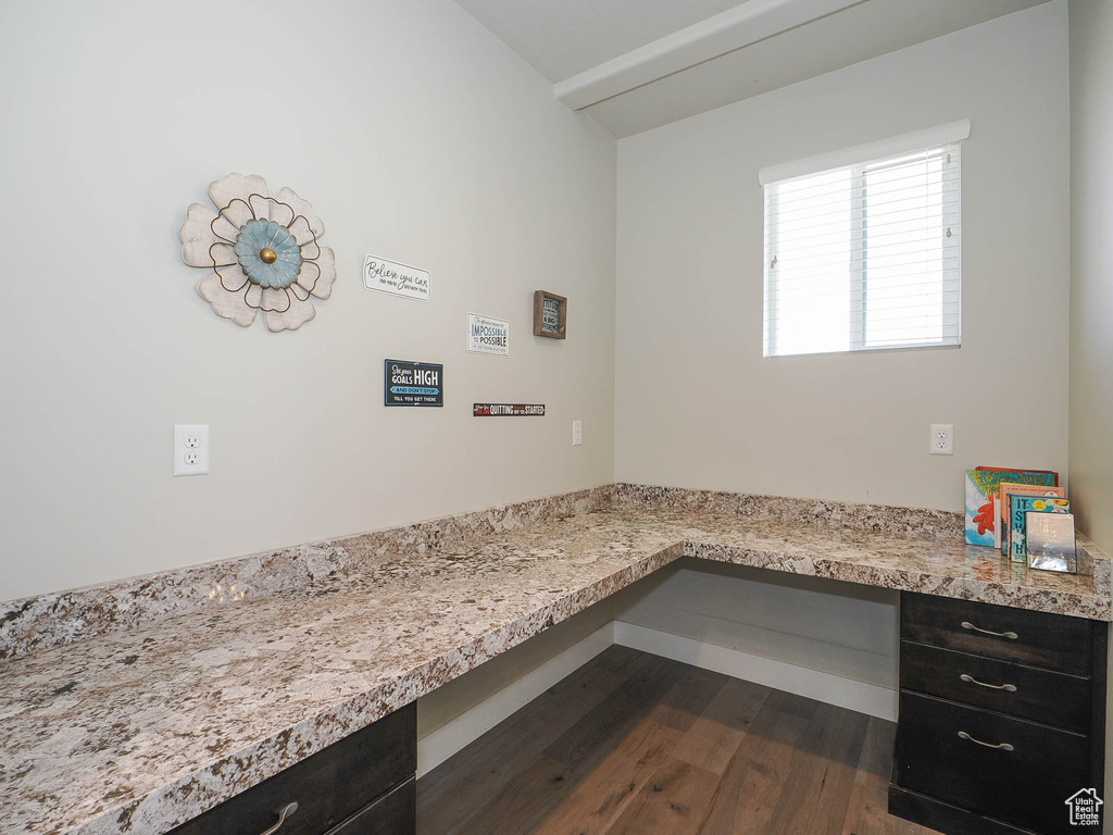 Office space with dark hardwood / wood-style flooring