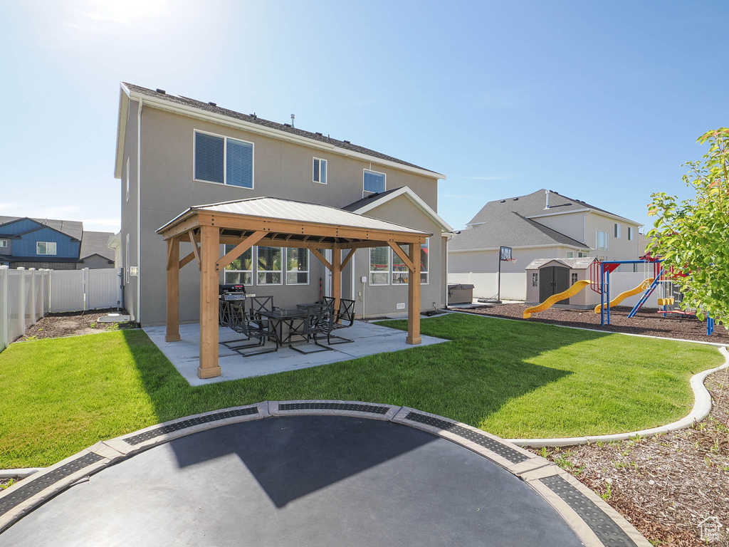 Back of house with a playground, a patio area, a yard, and a gazebo