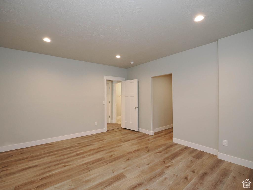 Empty room with light hardwood / wood-style floors