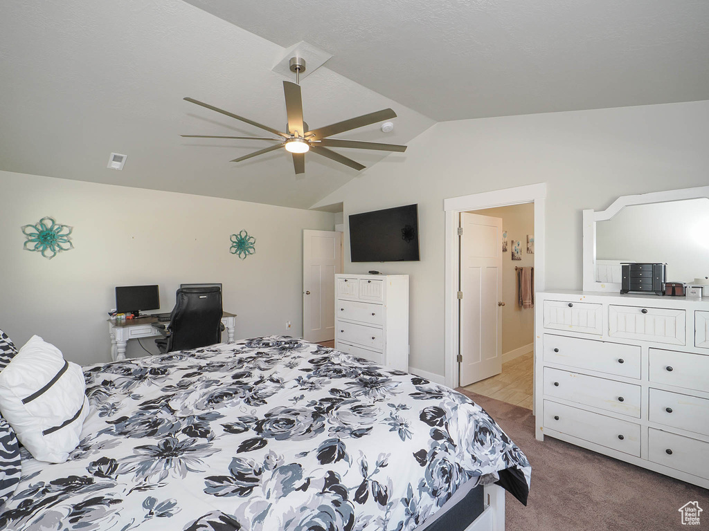 Carpeted bedroom with ceiling fan and lofted ceiling