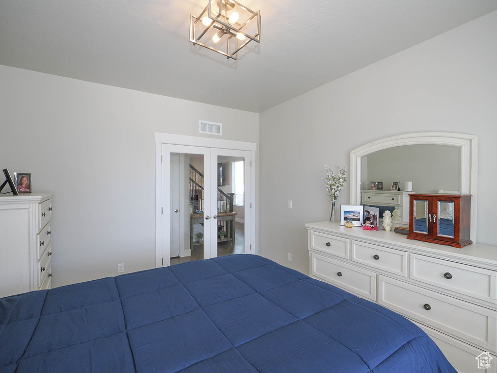 Unfurnished bedroom featuring a chandelier, french doors, and a closet