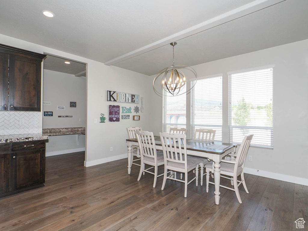 Dining area with dark hardwood / wood-style floors and an inviting chandelier