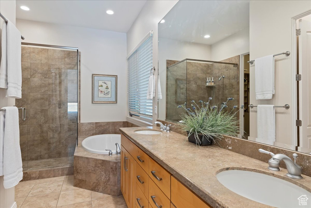 Bathroom featuring separate shower and tub, dual sinks, tile floors, and oversized vanity