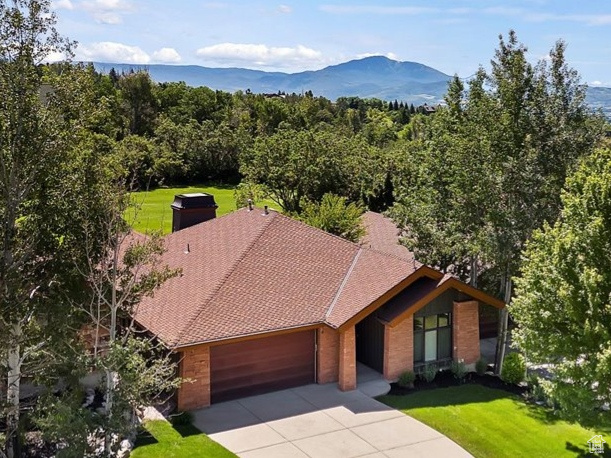 View of front facade with a garage and a mountain view