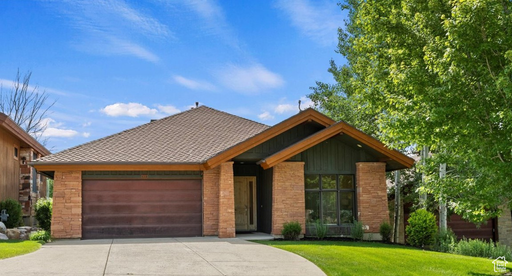 View of front of house with a garage and a front lawn