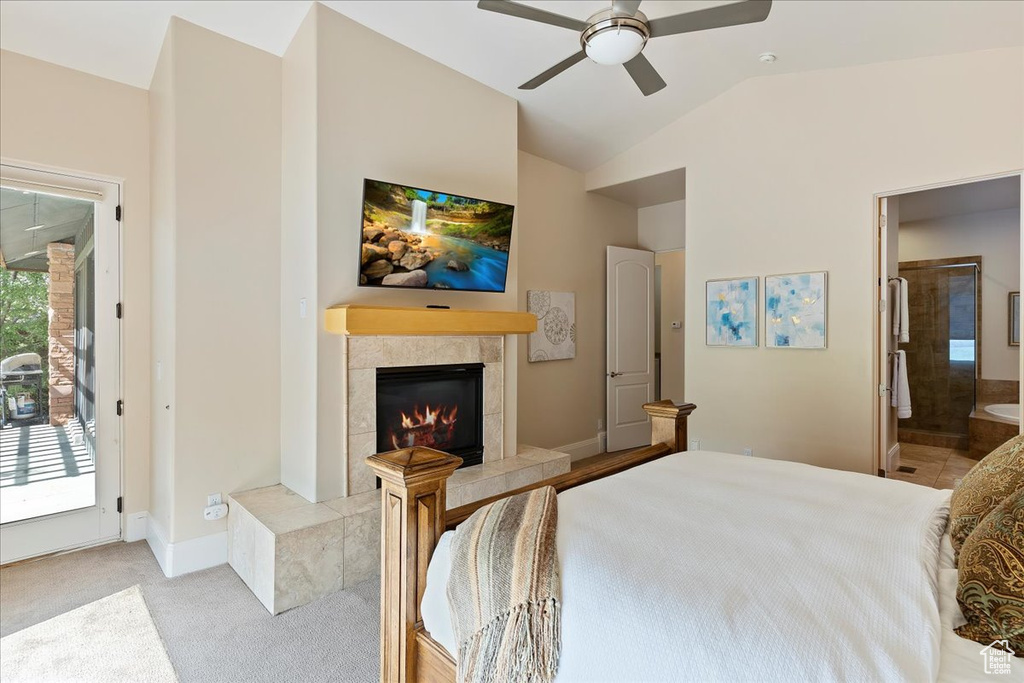 Carpeted bedroom with access to outside, a tiled fireplace, ceiling fan, and multiple windows