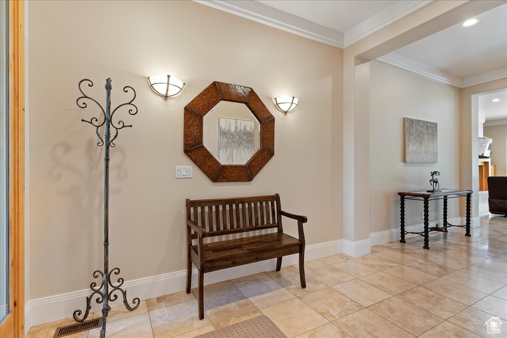 Hall featuring crown molding and light tile floors