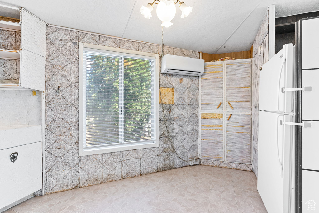 Interior space with an AC wall unit and a notable chandelier