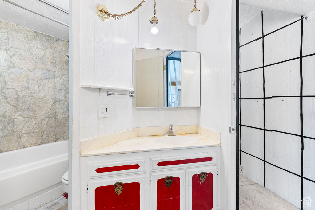 Full bathroom featuring tiled shower / bath combo, toilet, and vanity