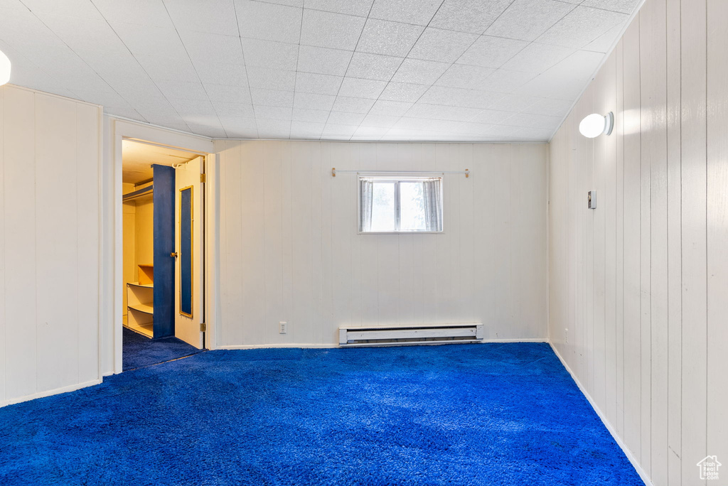 Carpeted empty room featuring baseboard heating