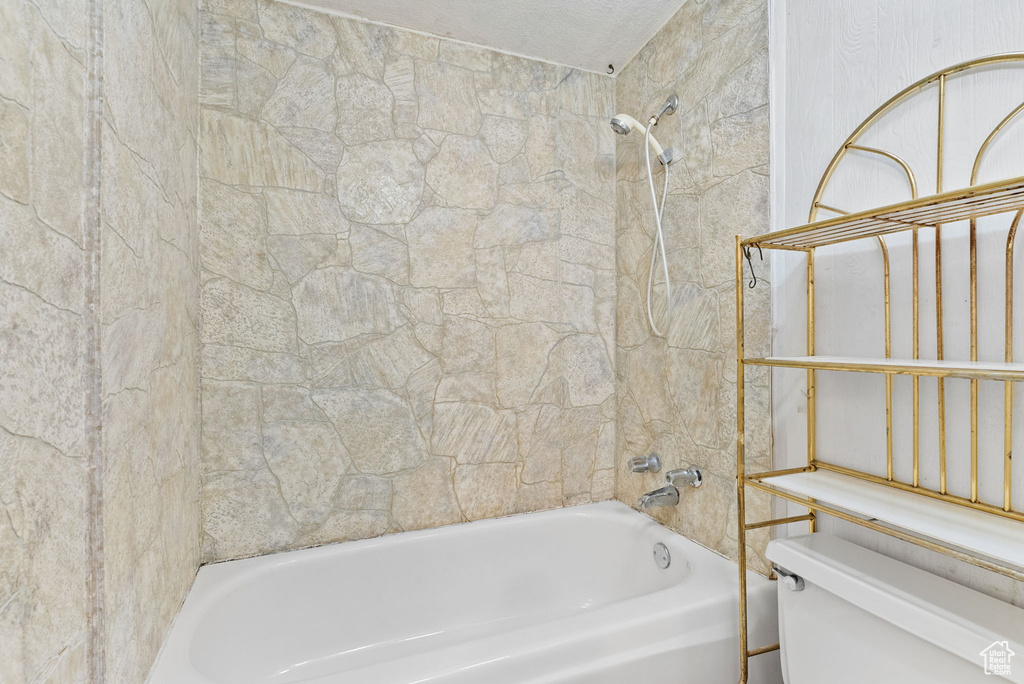 Bathroom with toilet and tiled shower / bath combo