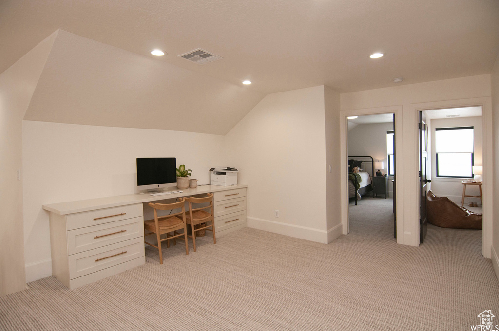 Office area featuring vaulted ceiling and light colored carpet