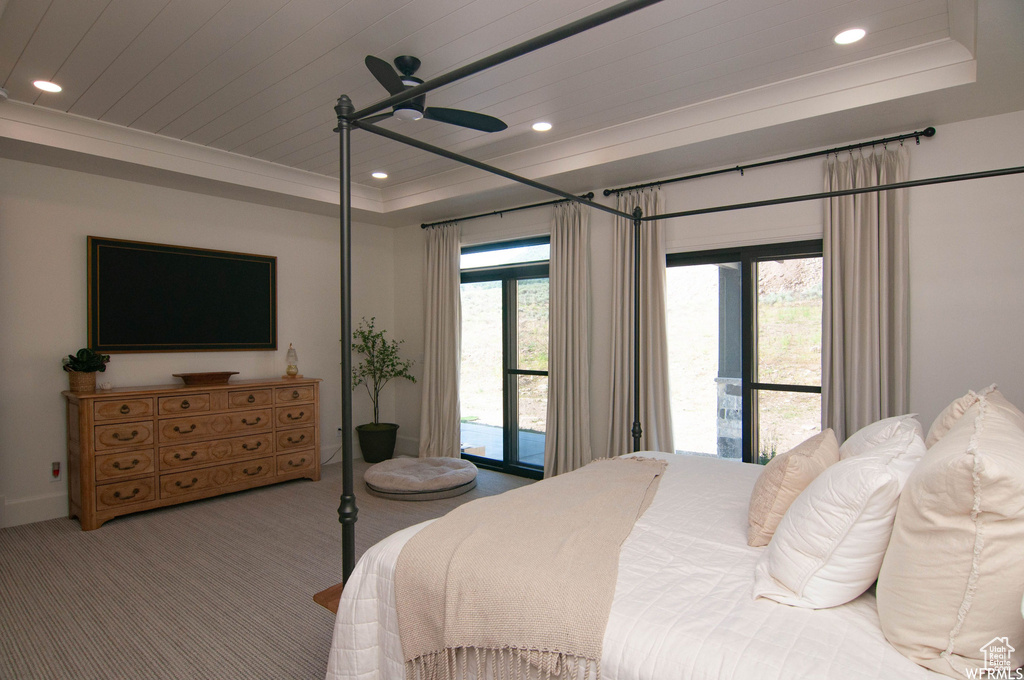 Bedroom with ceiling fan, a raised ceiling, access to outside, carpet, and ornamental molding