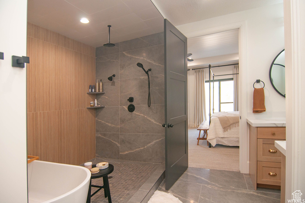 Bathroom featuring a tile shower and vanity