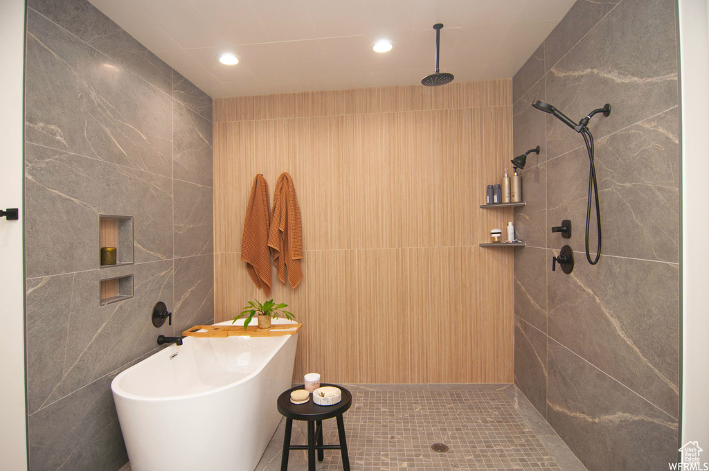 Bathroom featuring tiled shower, tile flooring, and tile walls