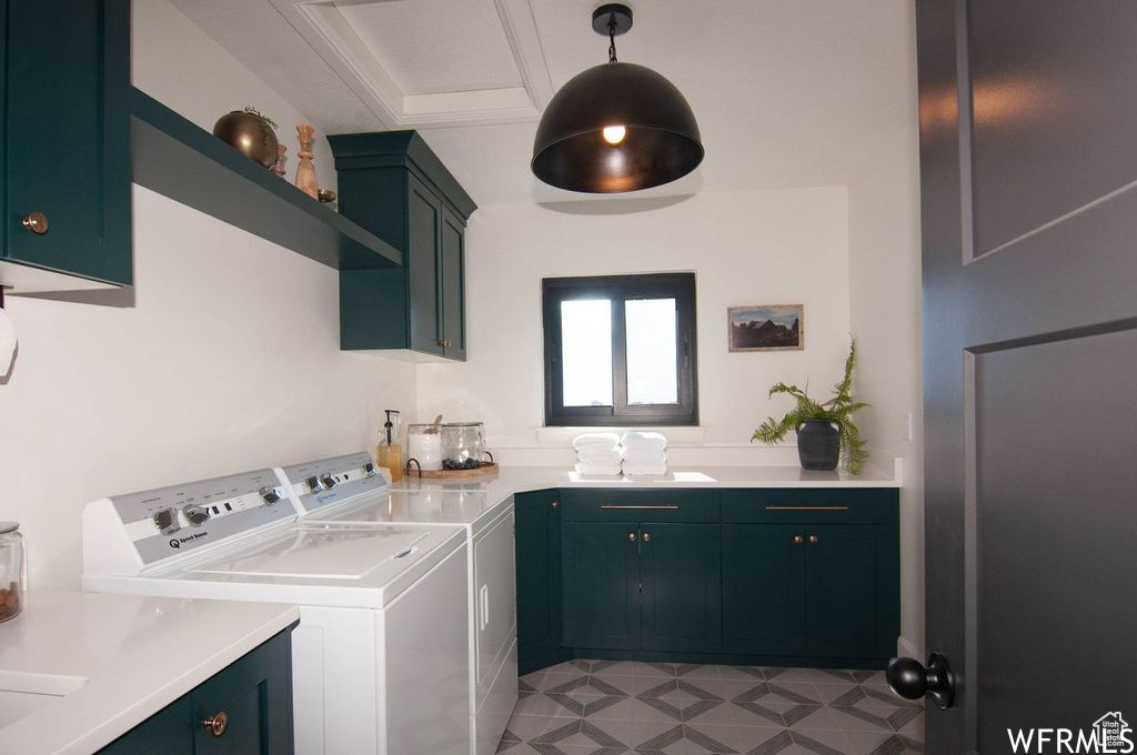 Laundry room featuring cabinets, light tile floors, and washing machine and dryer