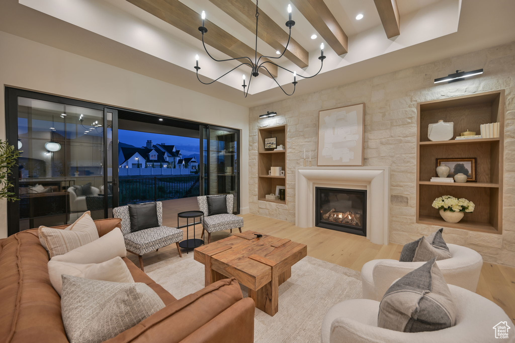 Living room with wood finished floors, beamed ceiling, built in features, recessed lighting, and a chandelier
