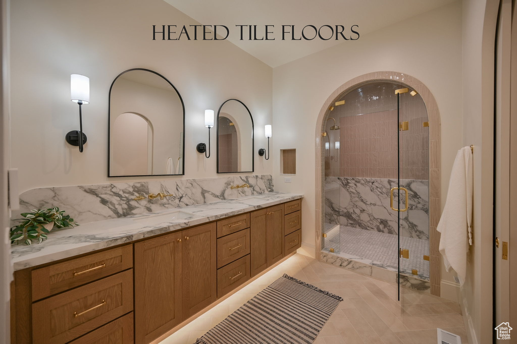 Full bathroom with a marble finish shower and double vanity