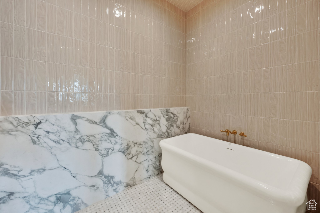 Full bath featuring tile walls and a freestanding bath