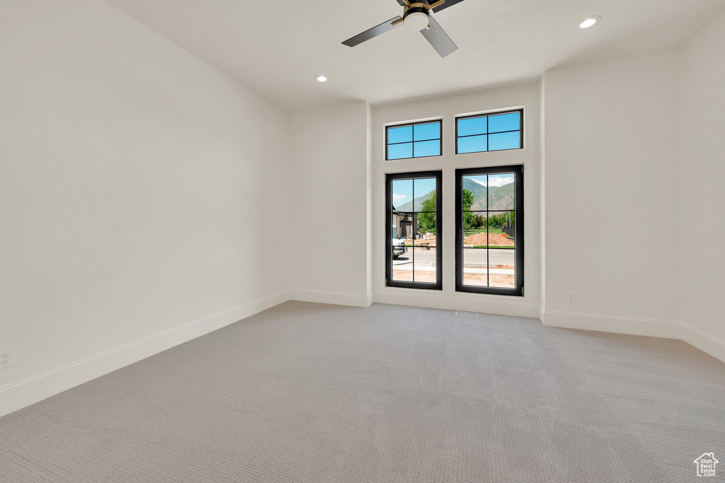 Spare room with light colored carpet, baseboards, ceiling fan, and recessed lighting