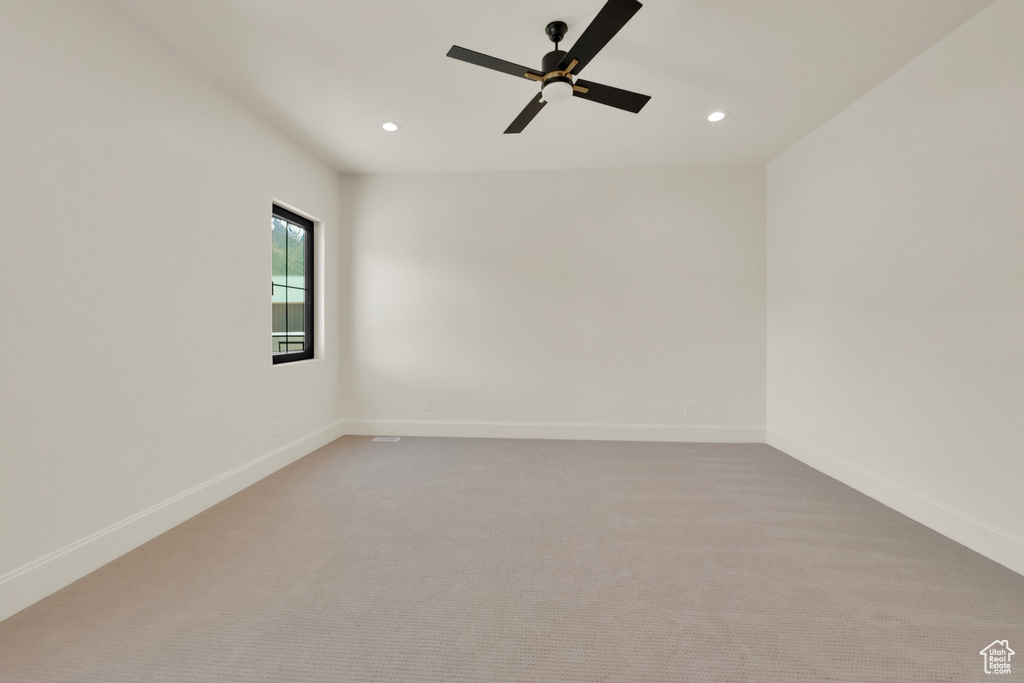 Spare room with recessed lighting, light colored carpet, a ceiling fan, and baseboards