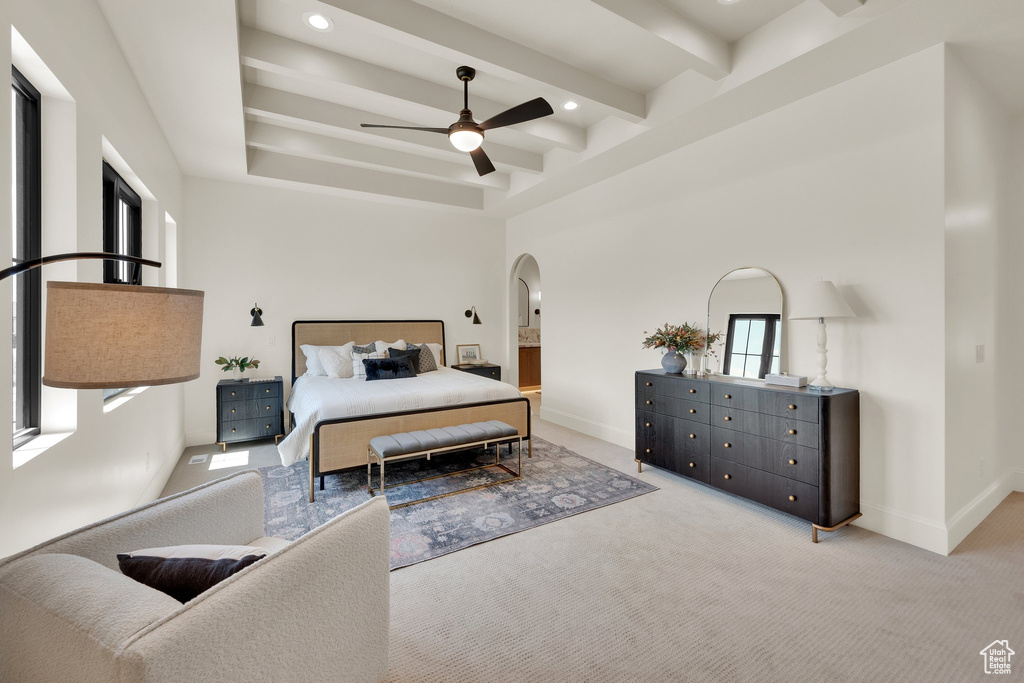 Carpeted bedroom featuring arched walkways, beam ceiling, baseboards, recessed lighting, and ceiling fan
