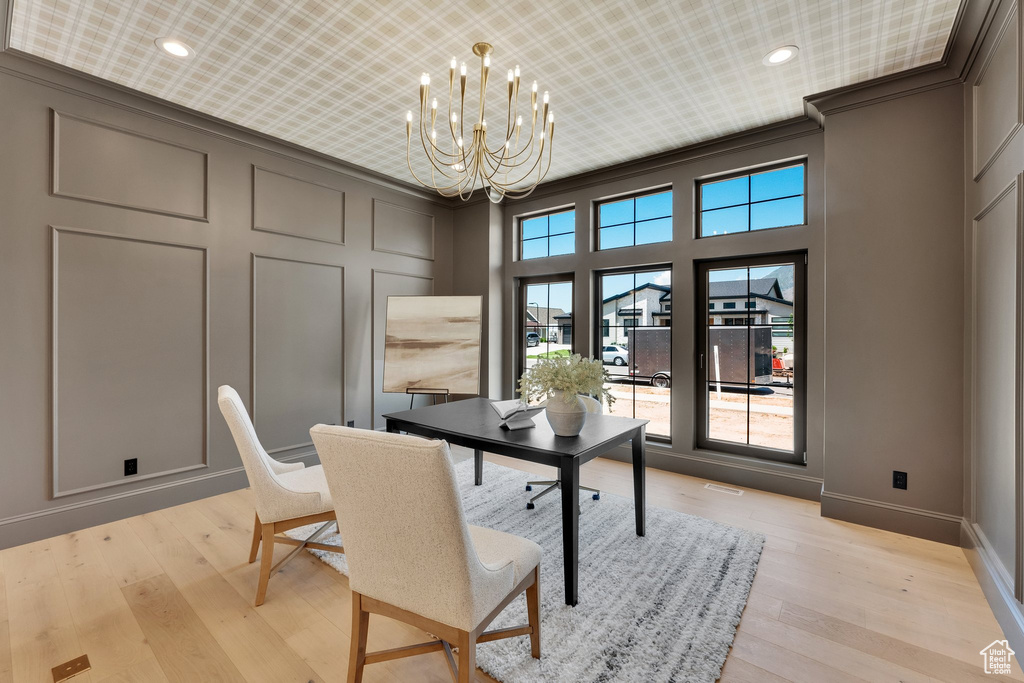 Office featuring a chandelier, a decorative wall, baseboards, light wood-style floors, and ornamental molding