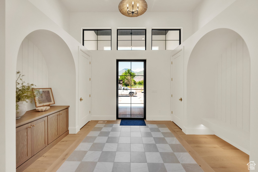 Entryway with a chandelier, light wood-style flooring, and baseboards