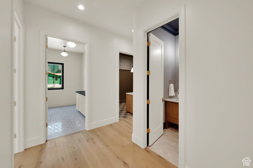 Hallway featuring light wood-style flooring, baseboards, and recessed lighting
