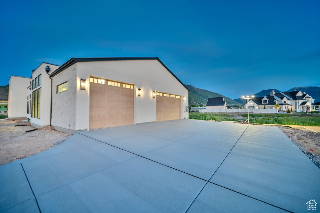 View of property exterior with driveway, stucco siding, and a residential view
