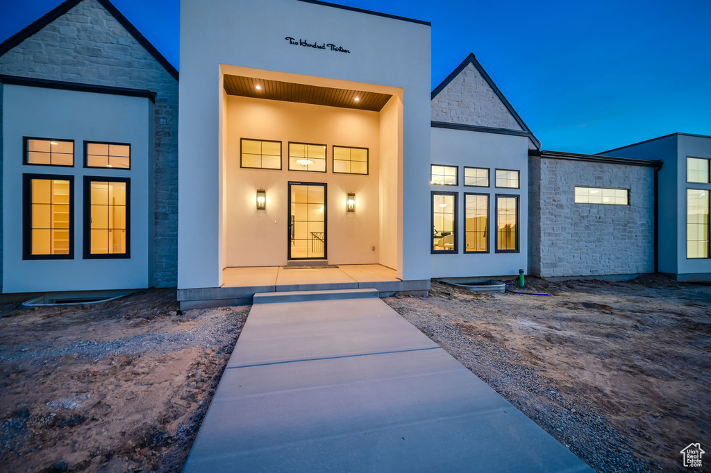 Back of house with stone siding and stucco siding