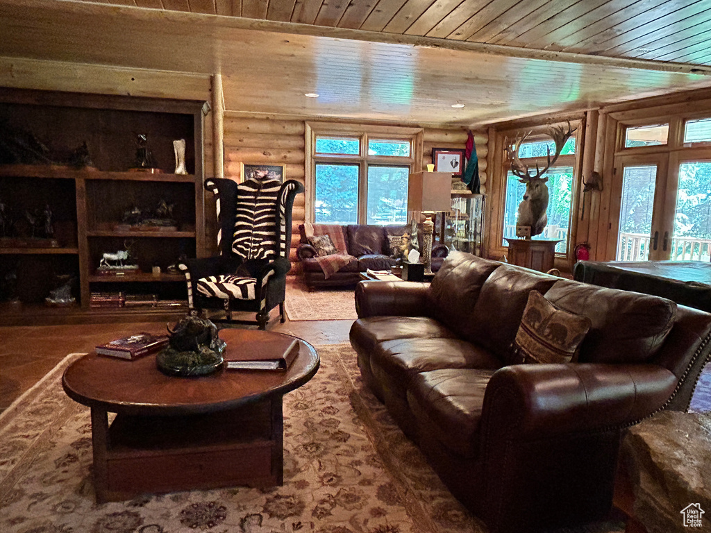 Living room featuring rustic walls and wood ceiling