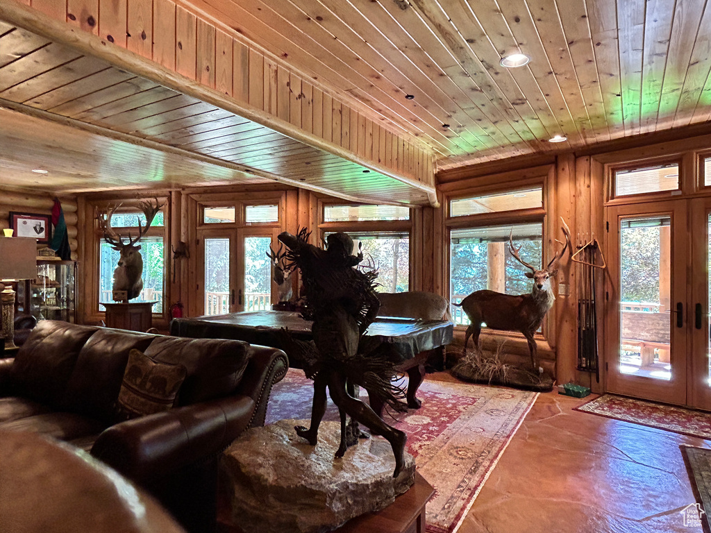Living room featuring a healthy amount of sunlight, french doors, and wood ceiling