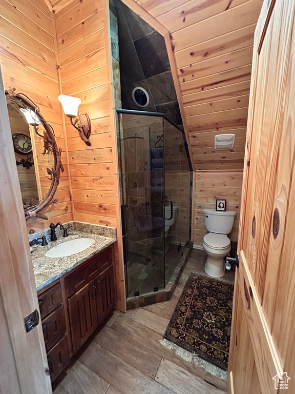 Bathroom featuring wooden ceiling, toilet, wooden walls, oversized vanity, and vaulted ceiling