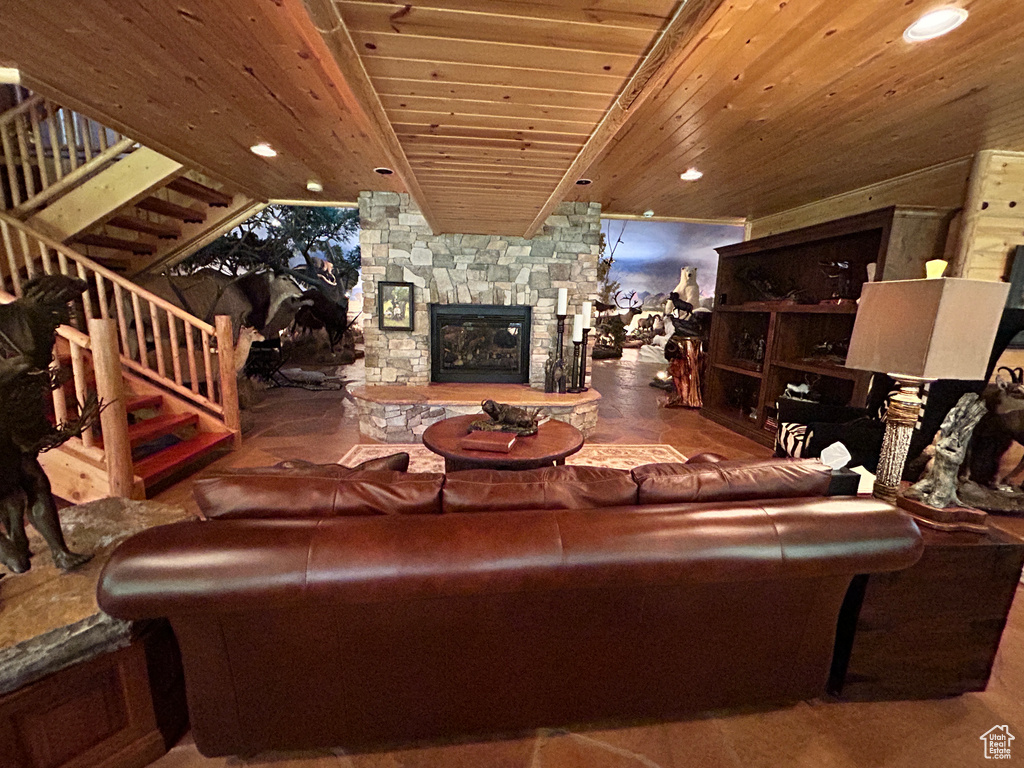 Living room featuring wooden ceiling and a stone fireplace