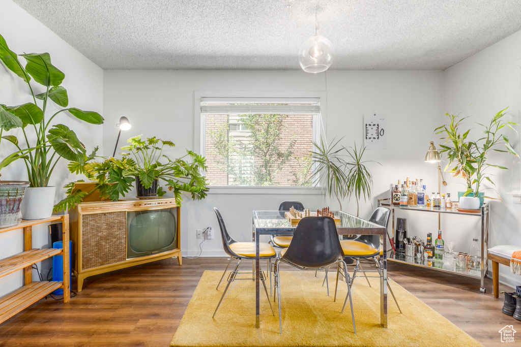 Dining area with hardwood / wood-style flooring and a textured ceiling