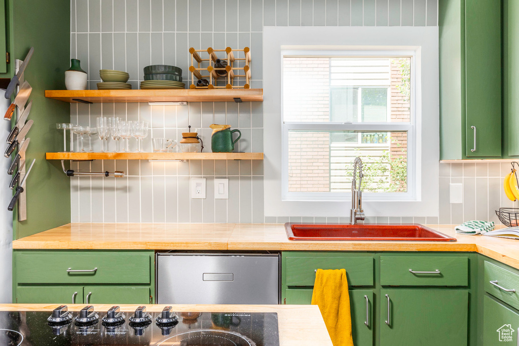 Kitchen with sink, backsplash, and green cabinetry