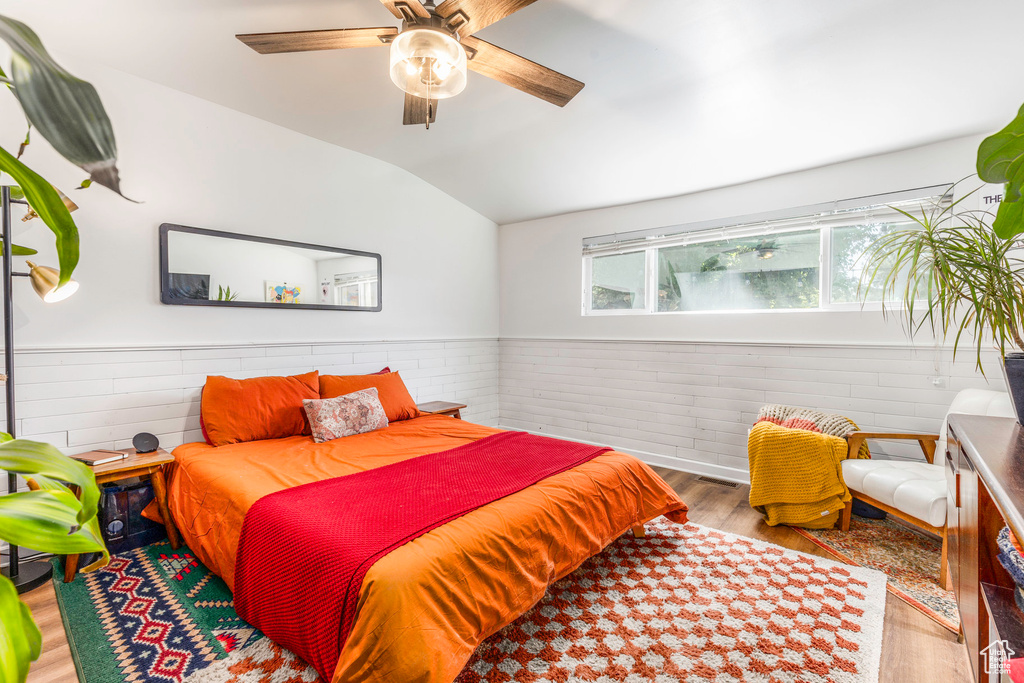 Bedroom with vaulted ceiling, ceiling fan, and hardwood / wood-style flooring