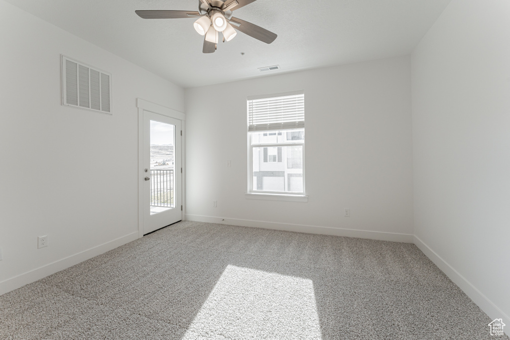 Empty room featuring ceiling fan and carpet floors