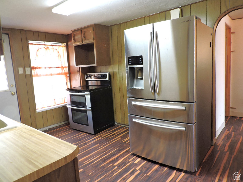 Kitchen with dark wood-type flooring and appliances with stainless steel finishes